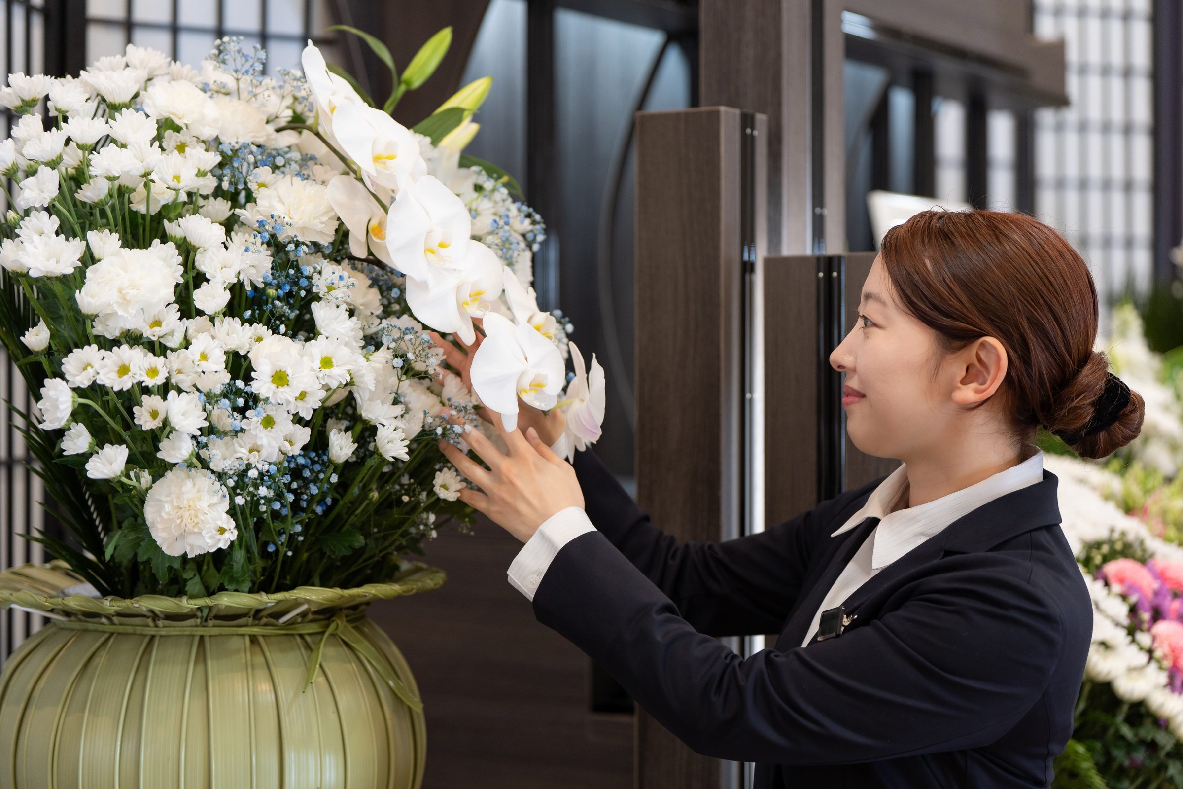 お見送りの花を整えるスタッフ