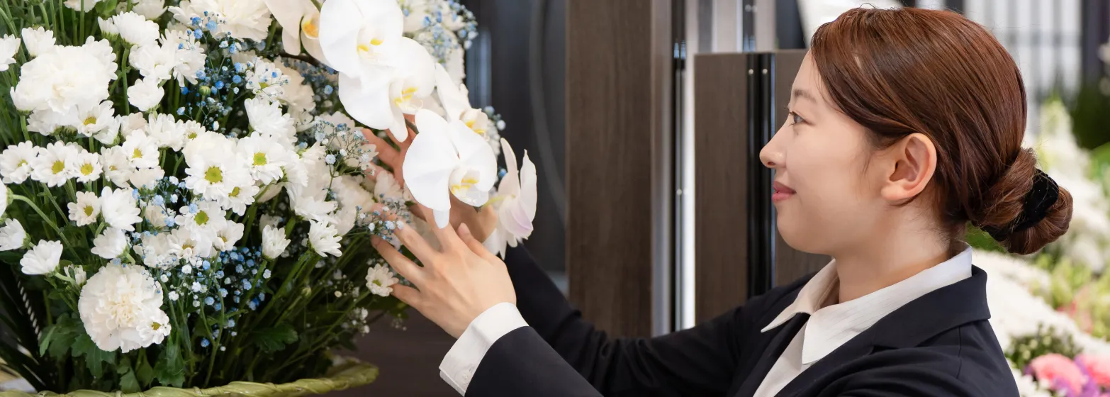 祭壇の花を整えるスタッフ