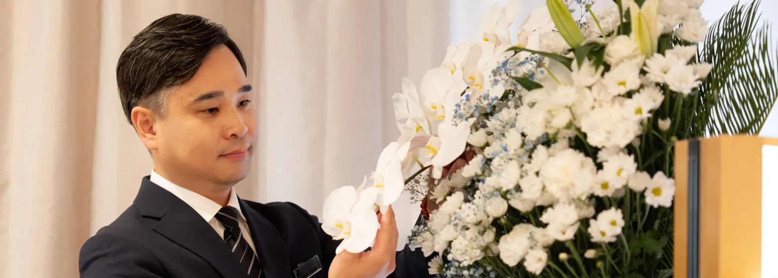 祭壇の花を整えるスタッフ